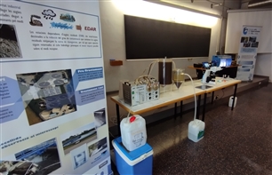 sala on es veu un taulell amb aparells, tubs i bidons d'aigua